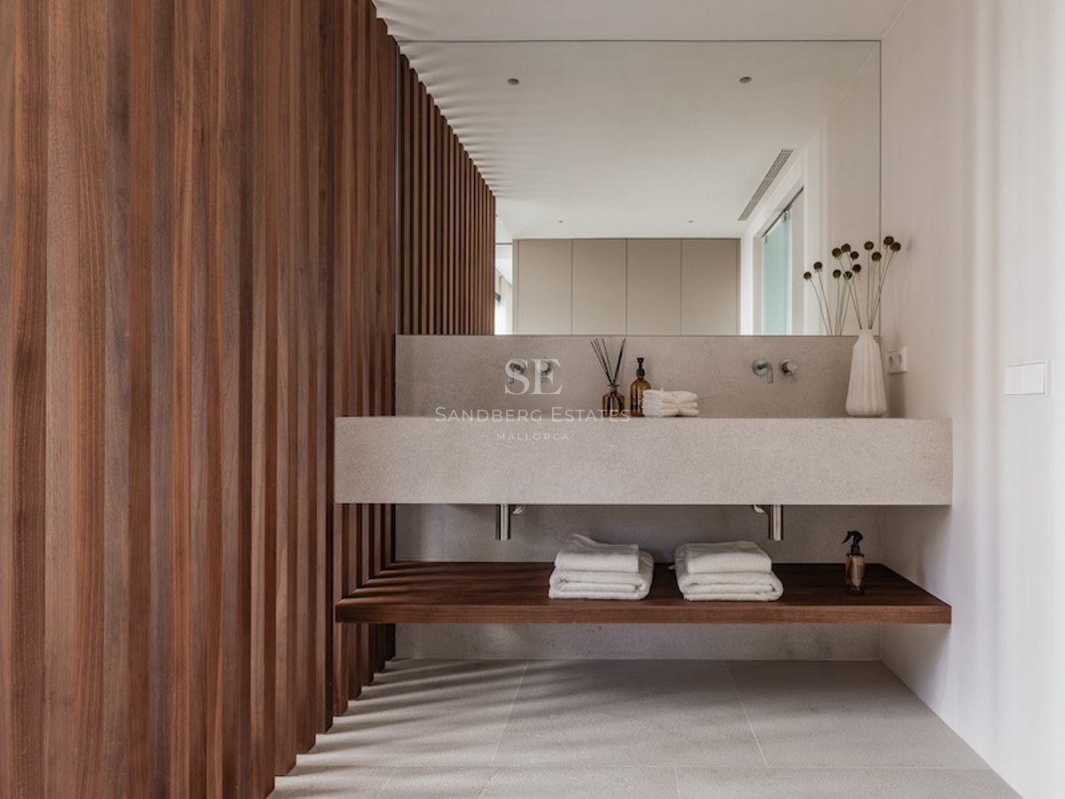 Modernes Badezimmer mit schwebendem Doppelwaschtisch aus Stein, großem Spiegel und dunkler Holzlamellenwand.
