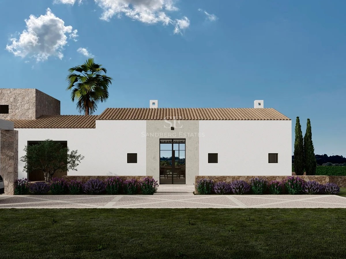Exterior view of a white modern villa with stone accents, terracotta roof, and lavender bushes under a clear blue sky.