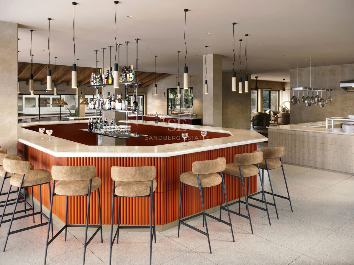 Modern bar with marble countertop, ribbed terracotta base, and high stools in a bright social space.