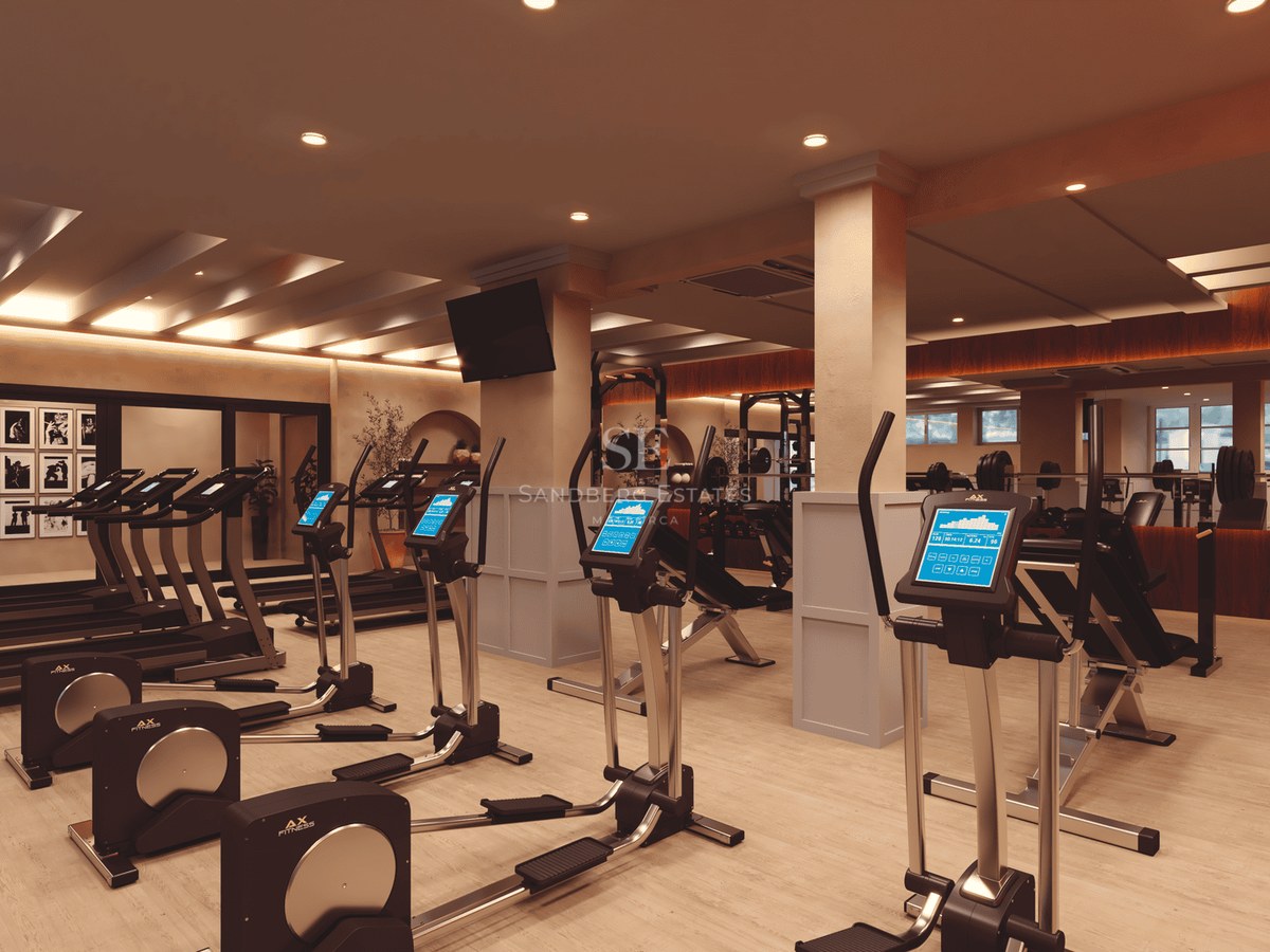Interior of a modern high-end gym featuring elliptical machines, treadmills, and weights in a stylish setting.