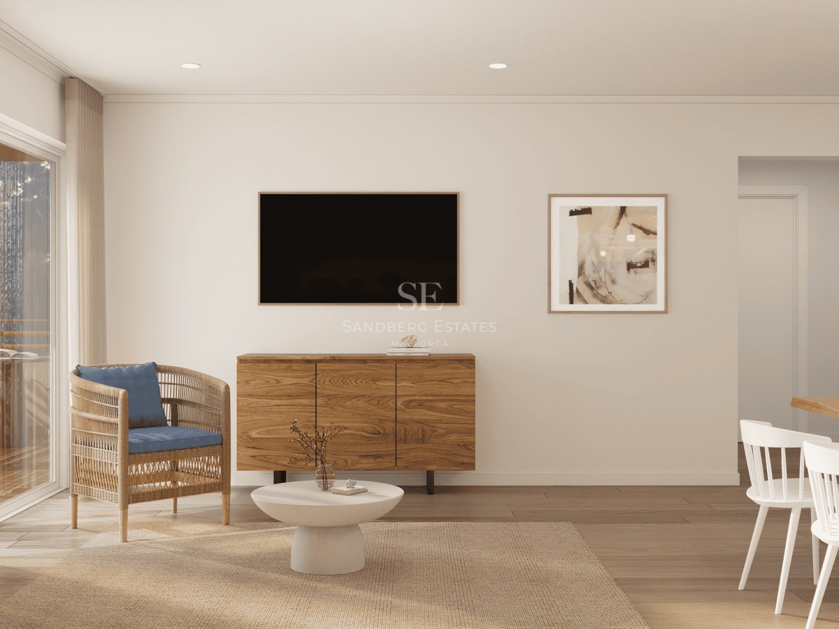Minimalist living room featuring a wicker chair, wall-mounted TV, and warm wood sideboard.