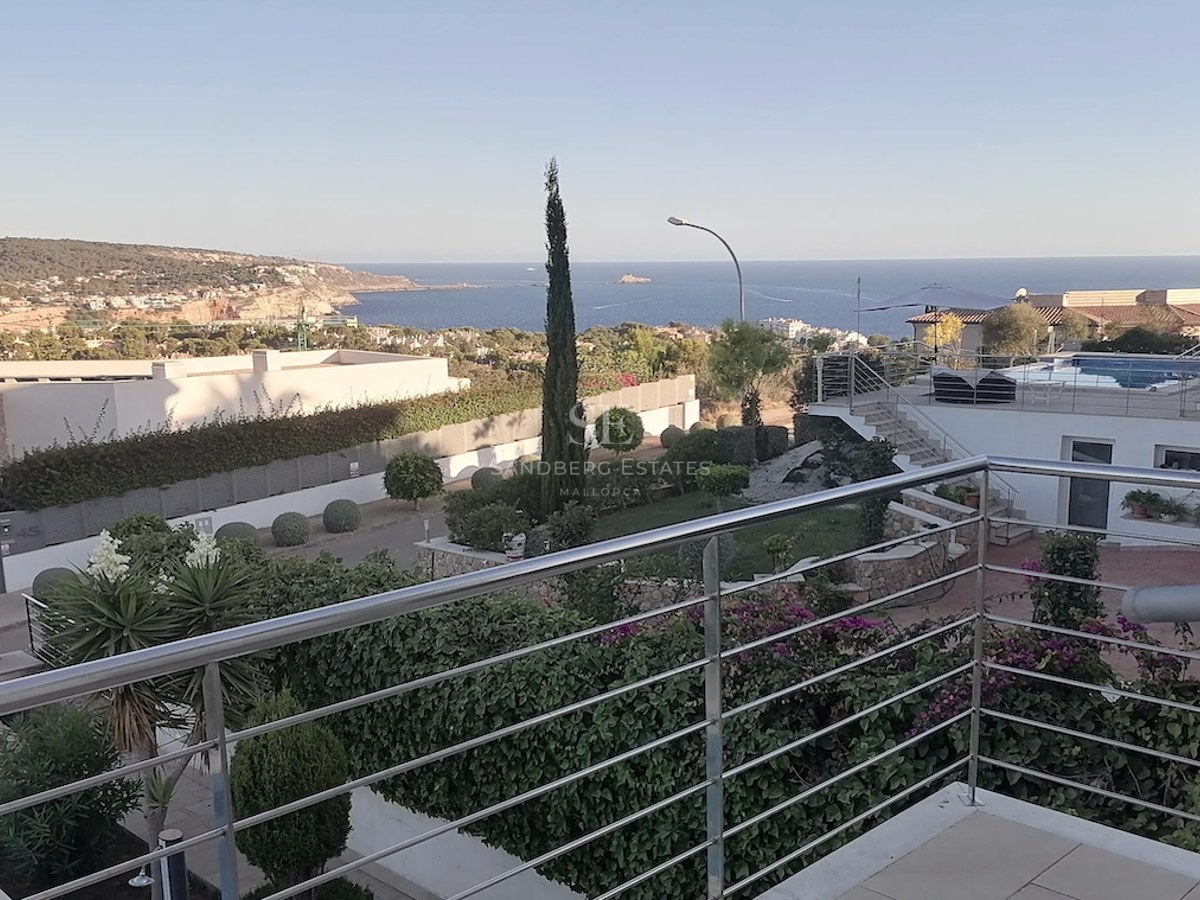 Elevated view from a terrace with stainless steel railings overlooking the Mediterranean Sea and coastal hills.