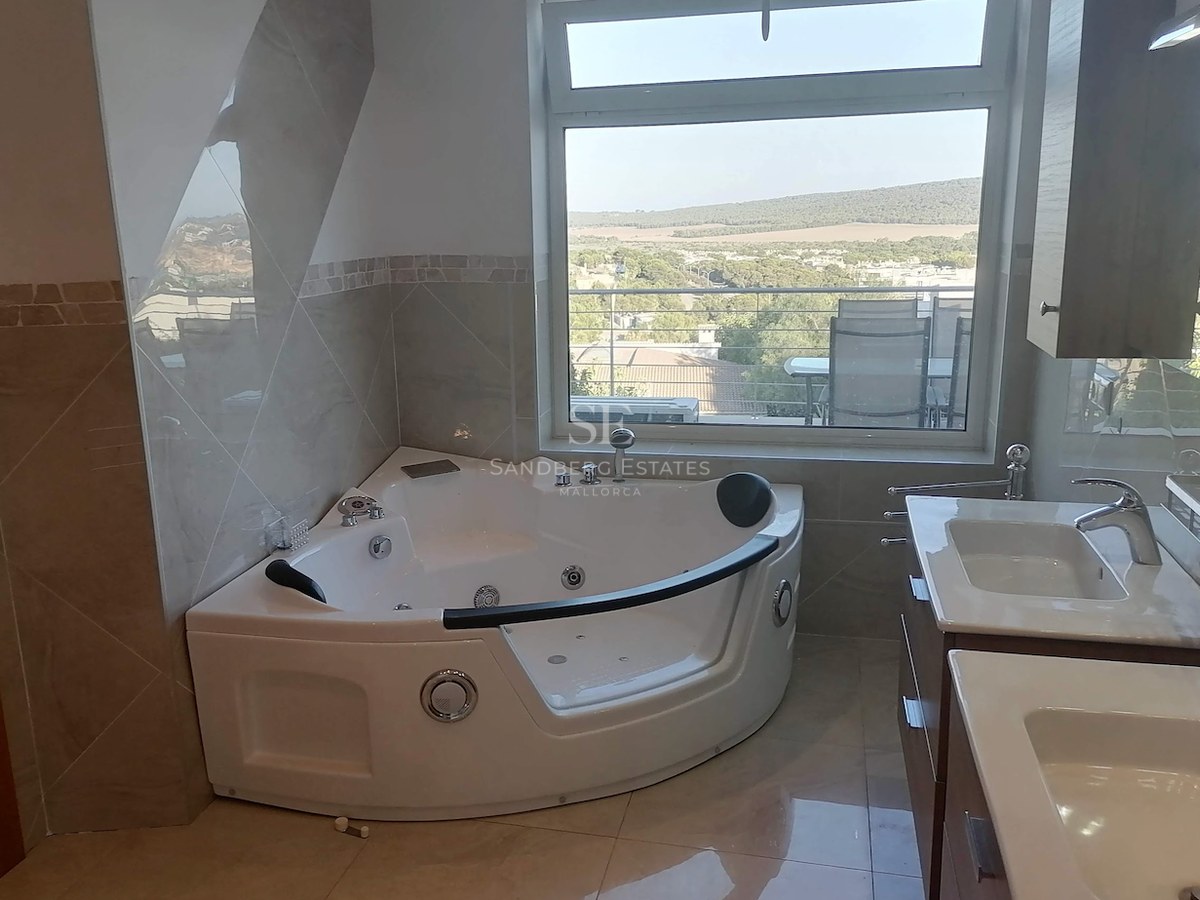 Contemporary bathroom featuring a corner jacuzzi, double vanity, and a large window overlooking a scenic valley.