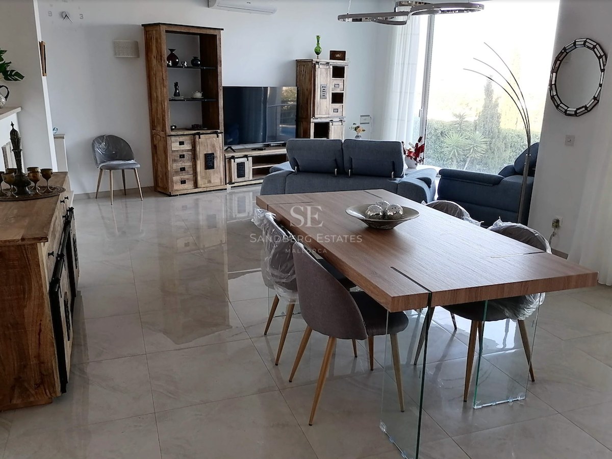 Spacious living and dining area featuring polished porcelain tiles, wooden cabinetry, and floor-to-ceiling windows.