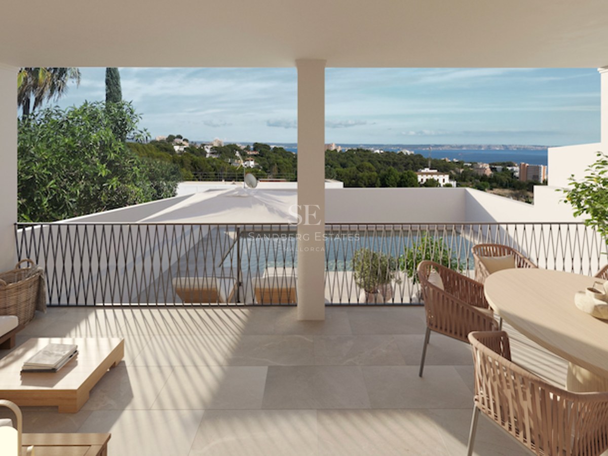 Terrasse couverte avec mobilier en rotin surplombant une piscine et la mer Méditerranée.