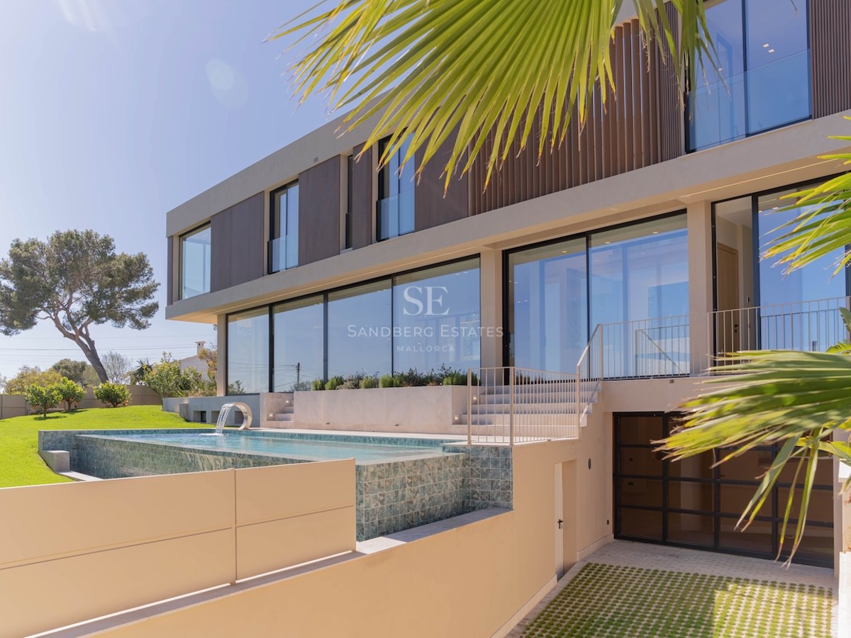 Vue extérieure d'une villa moderne avec piscine à débordement, façade vitrée et jardin paysager.