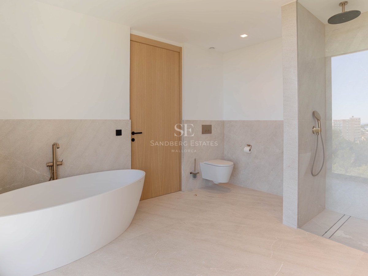 Salle de bains contemporaine avec baignoire îlot blanche, douche à l'italienne et carrelage tons sable.