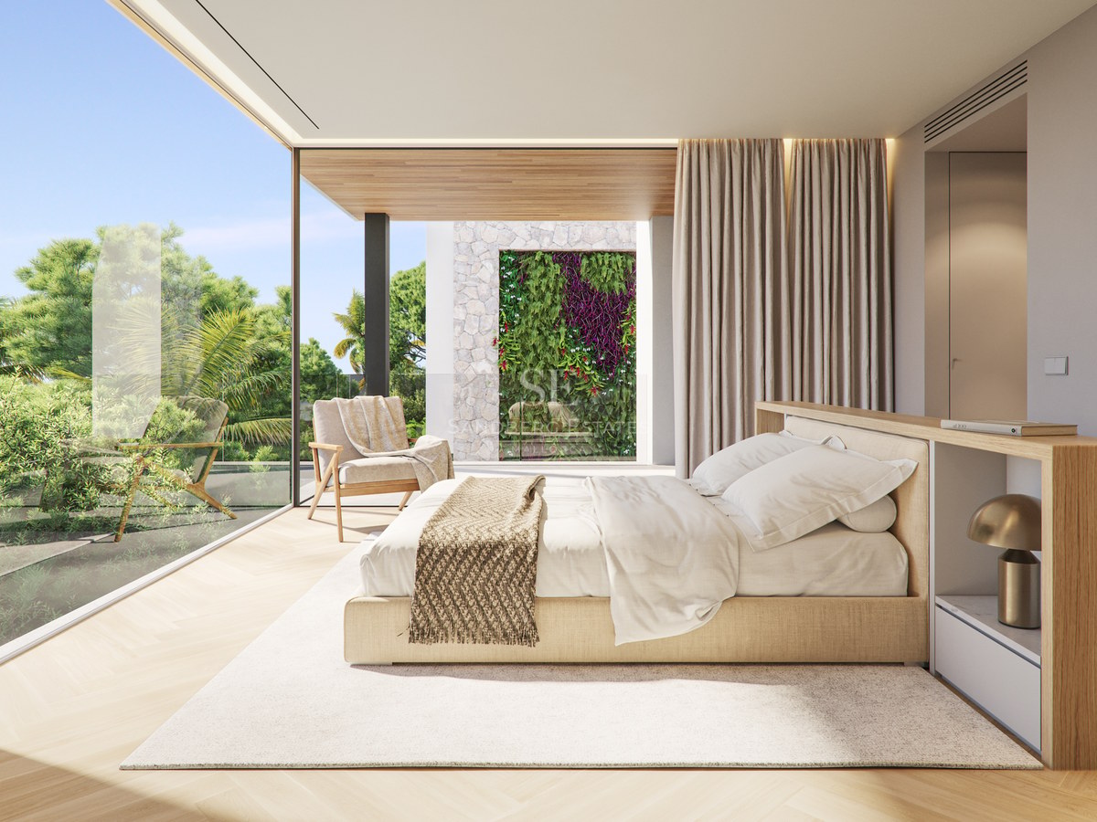 Chambre de maître minimaliste avec baies vitrées donnant sur un jardin verdoyant et un mur végétal.