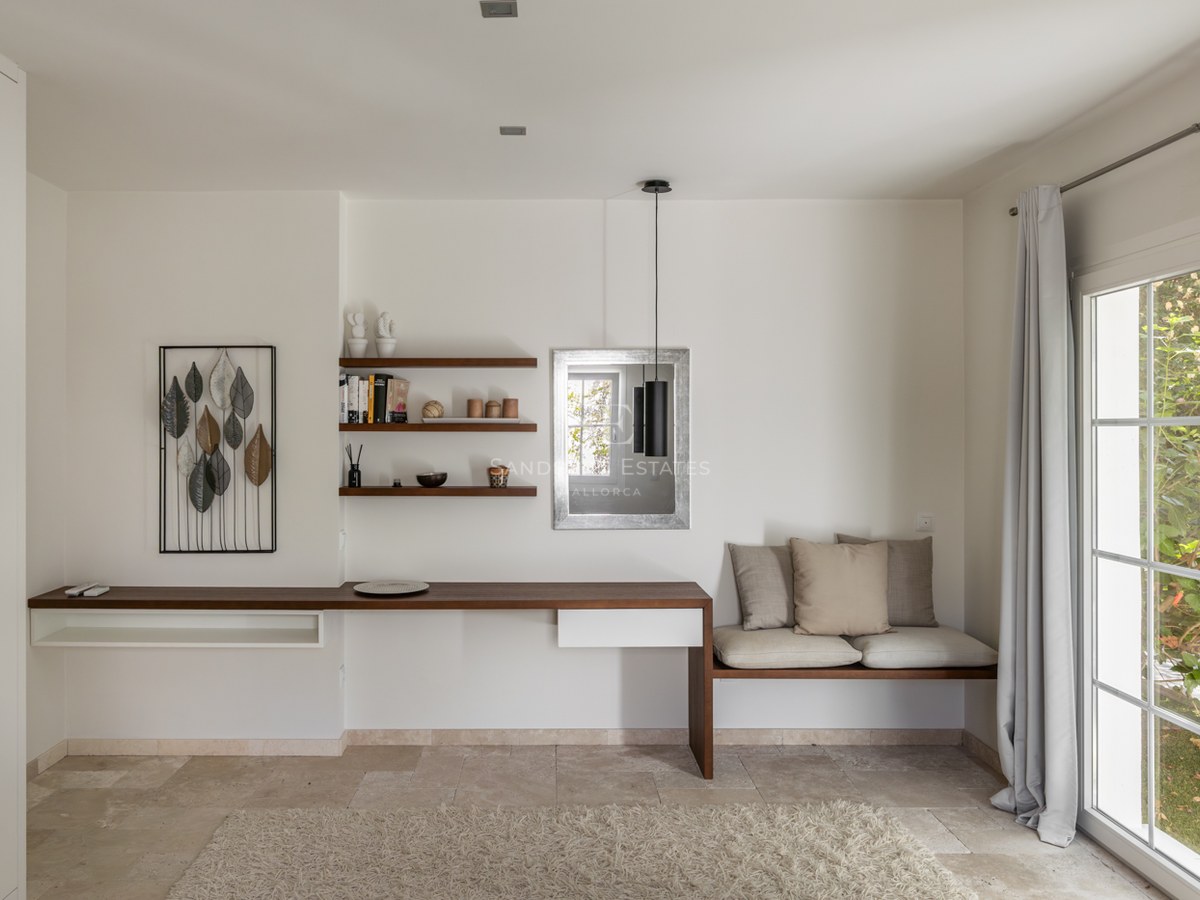 Bureau minimaliste moderne avec bureau flottant en bois, sol en pierre naturelle et banquette intégrée.