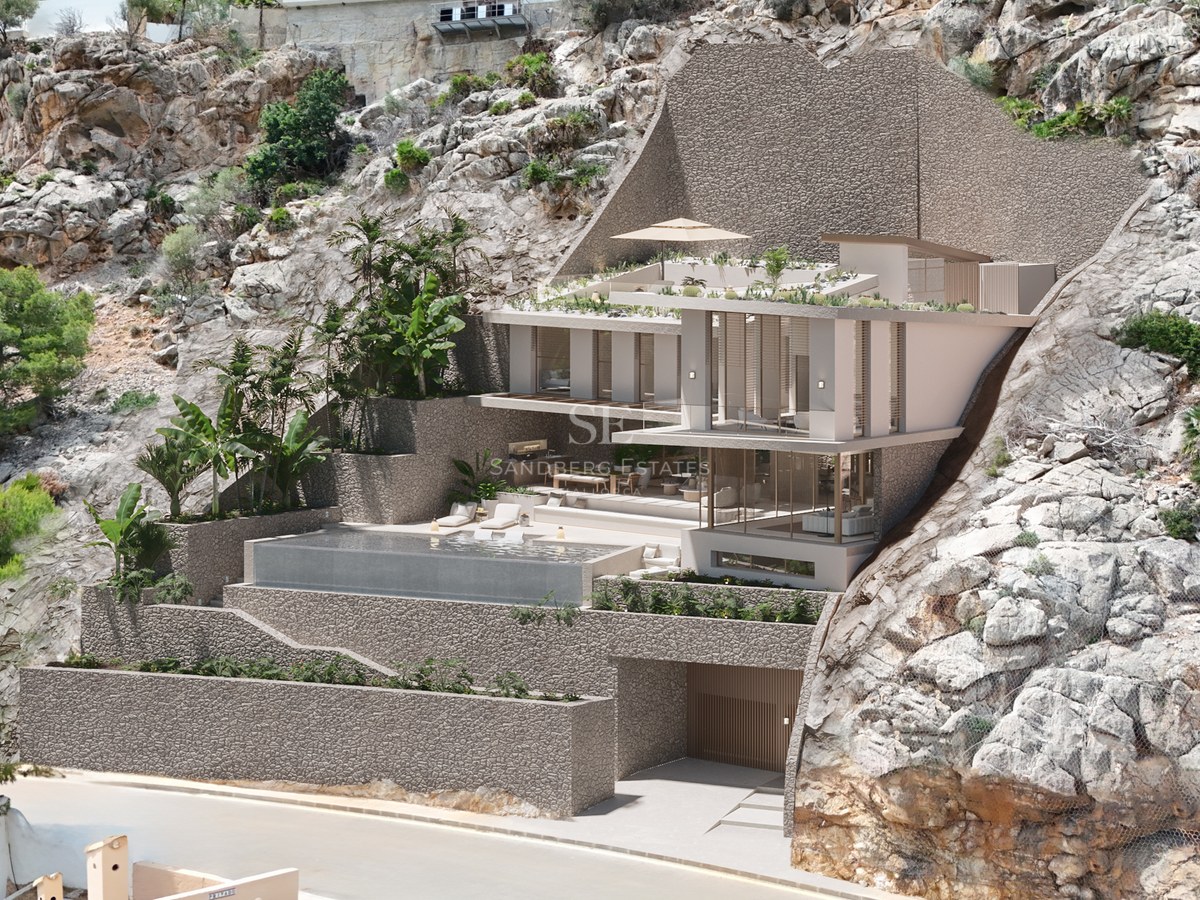 Modern multi-level villa built into a rocky cliff with an infinity pool, glass walls, and lush tropical greenery.