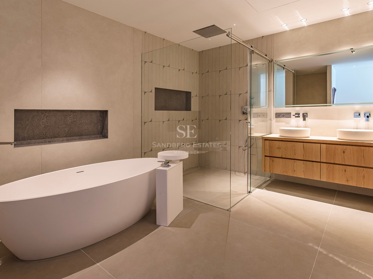 Salle de bains moderne avec baignoire îlot blanche, douche à l'italienne vitrée et double vasque en chêne.