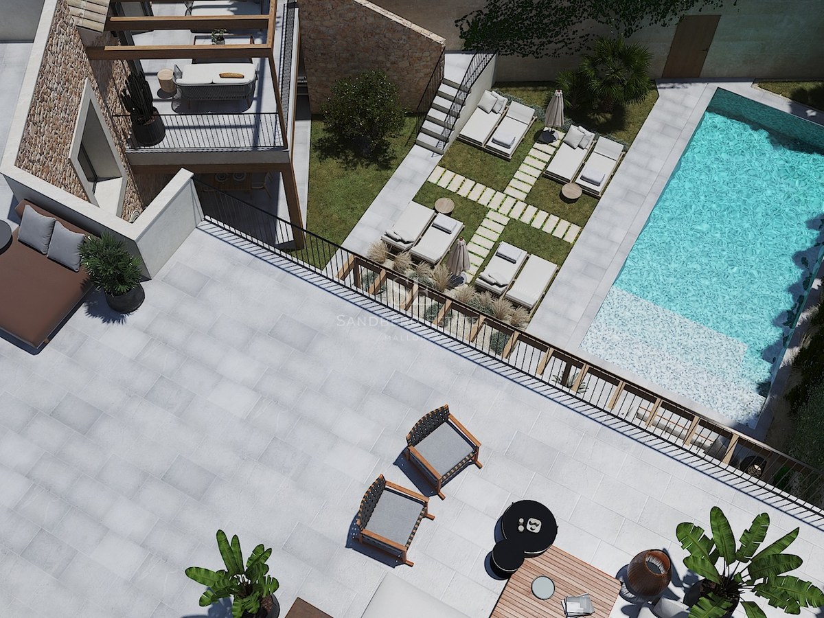 Vue aérienne d'une villa moderne avec piscine turquoise, murs en pierre et grands espaces de détente extérieurs.