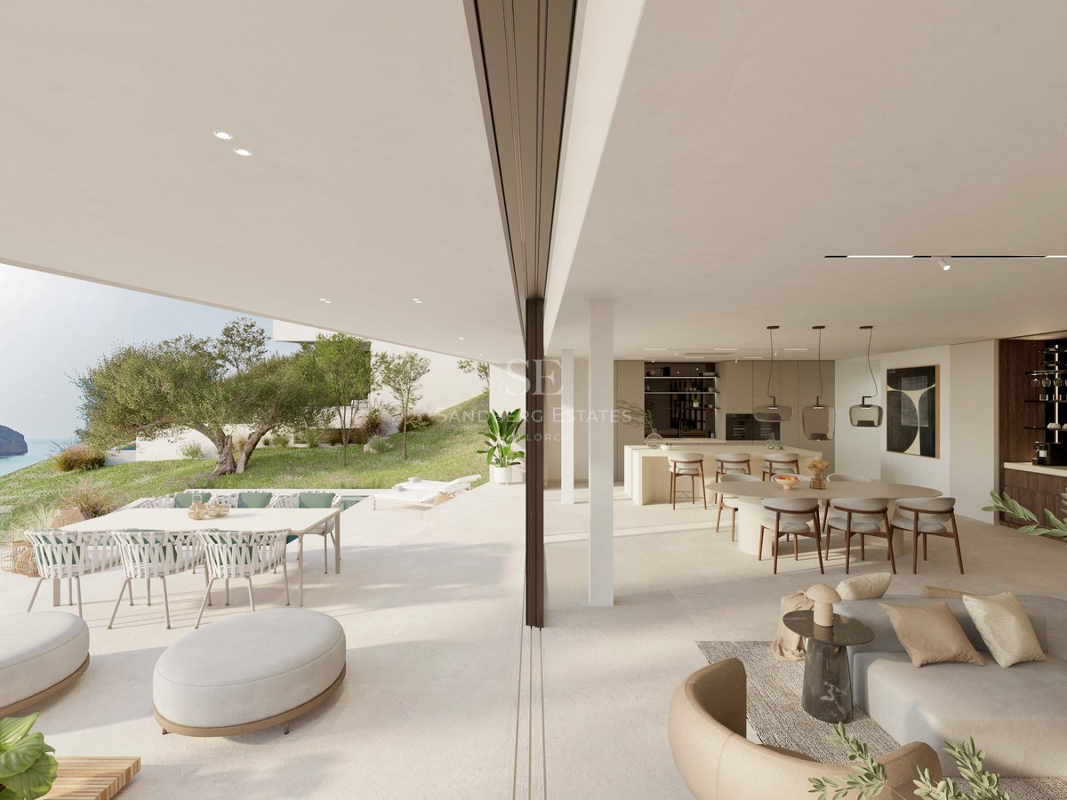 Bright, open-plan living and dining room merging with a spacious terrace overlooking the sea and coastline.