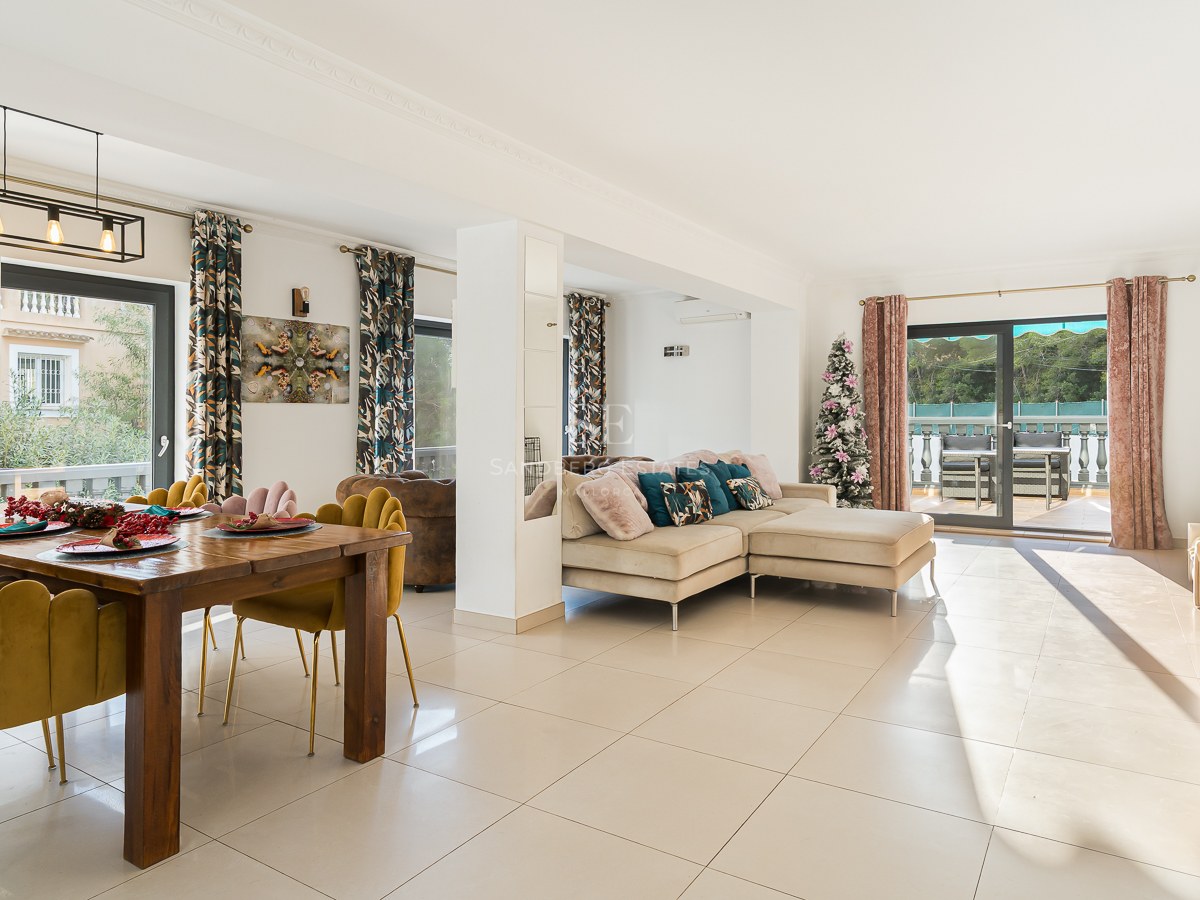 Bright living and dining room featuring mustard velvet chairs, a beige sofa, and large sliding doors to a terrace.