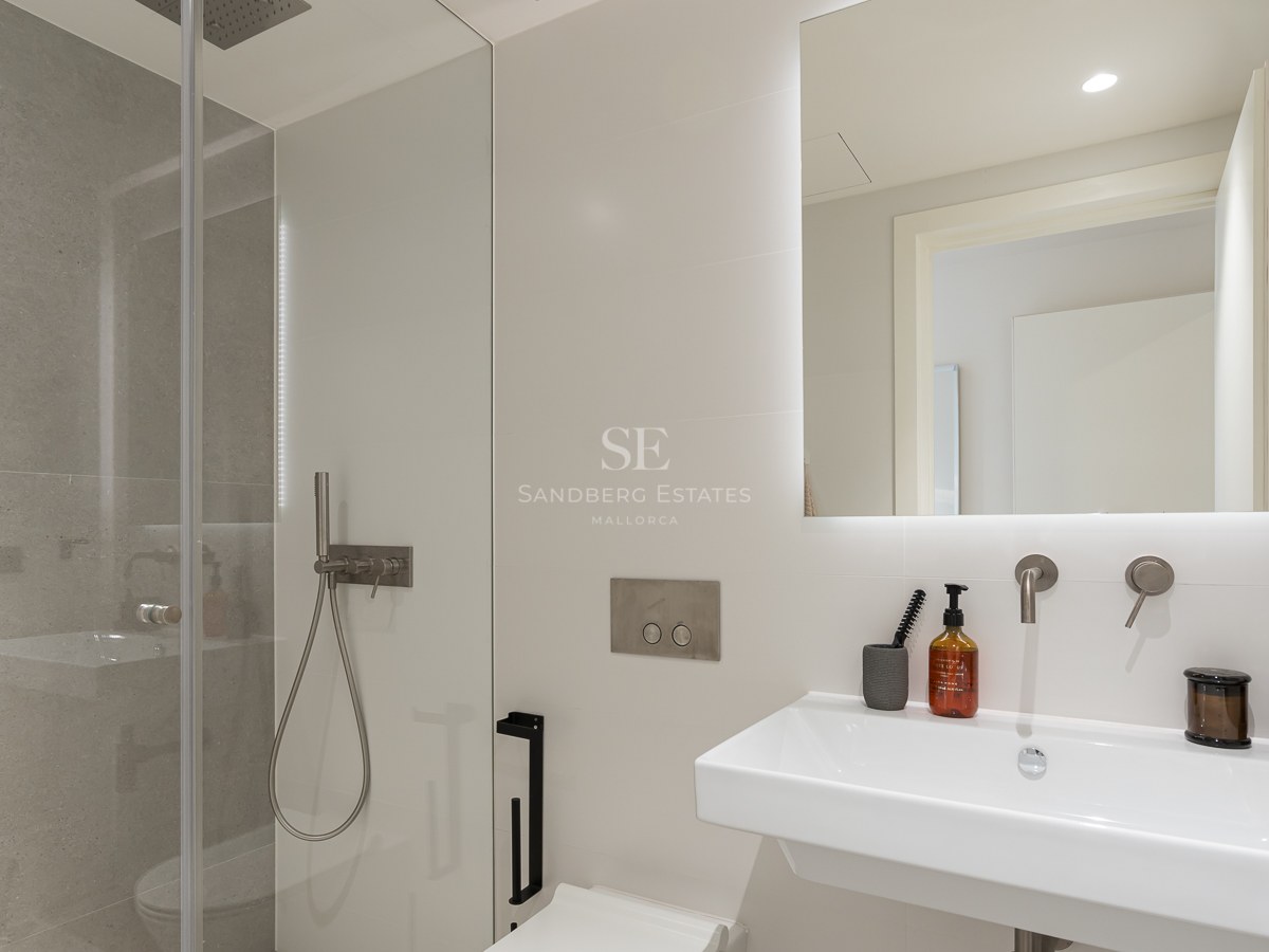 Salle de bains contemporaine avec douche à l'italienne, vasque blanche et grand miroir rétroéclairé.