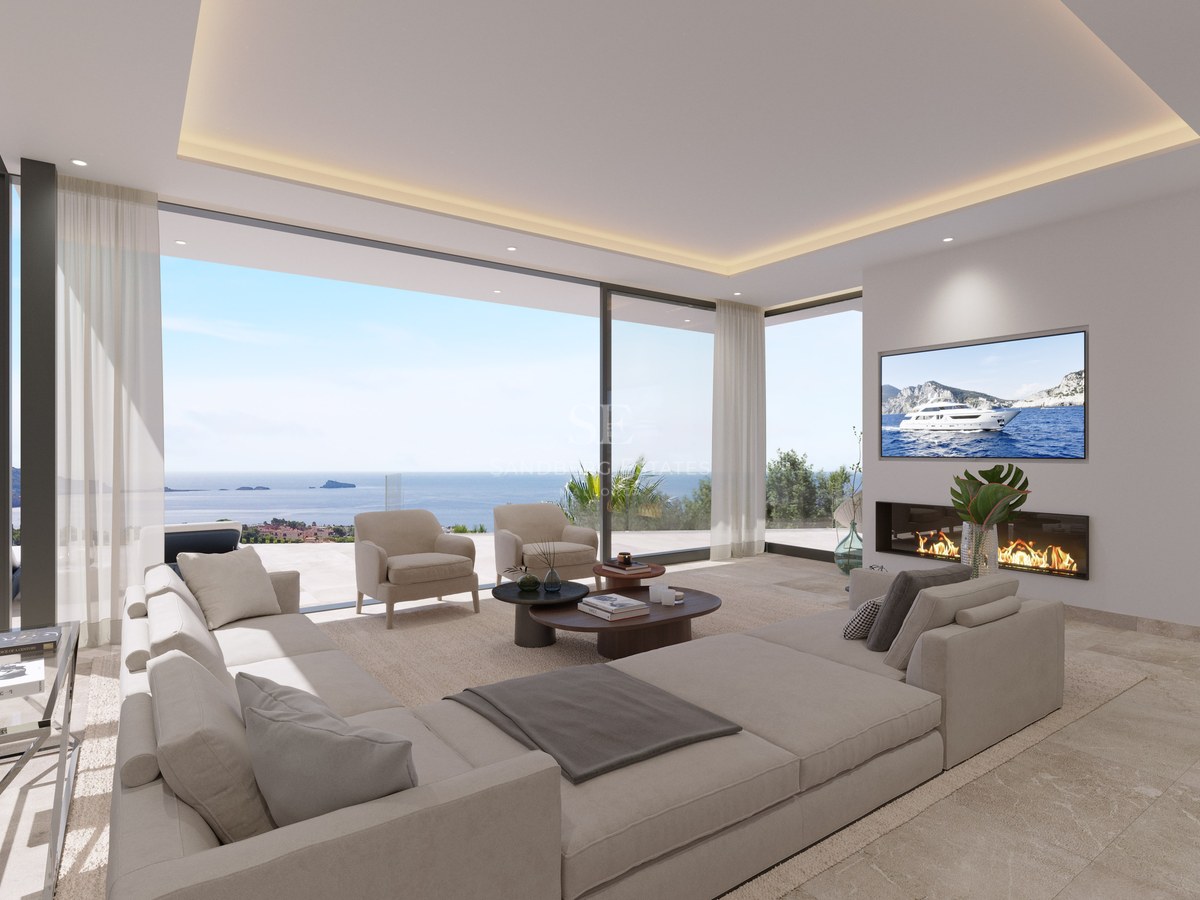 Salon contemporain avec grand canapé beige, cheminée linéaire et baies vitrées donnant sur la mer Méditerranée.