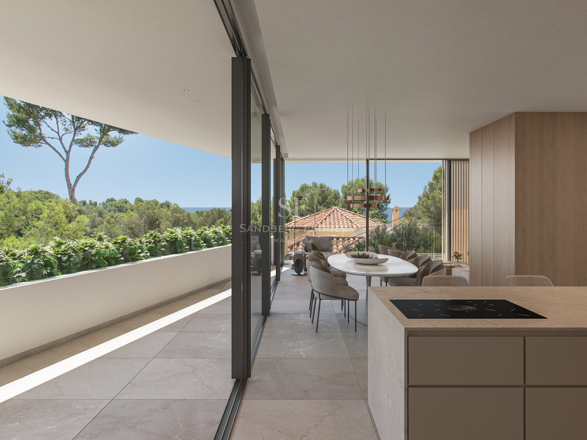 Salle à manger moderne à aire ouverte avec îlot de cuisine et grandes baies vitrées ouvrant sur une terrasse et la mer.