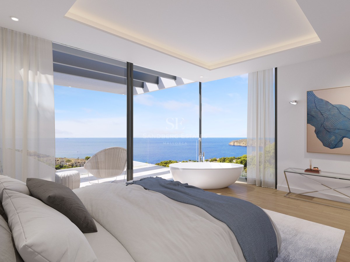 Chambre de luxe avec baignoire îlot et baies vitrées d'angle donnant sur la mer Méditerranée.