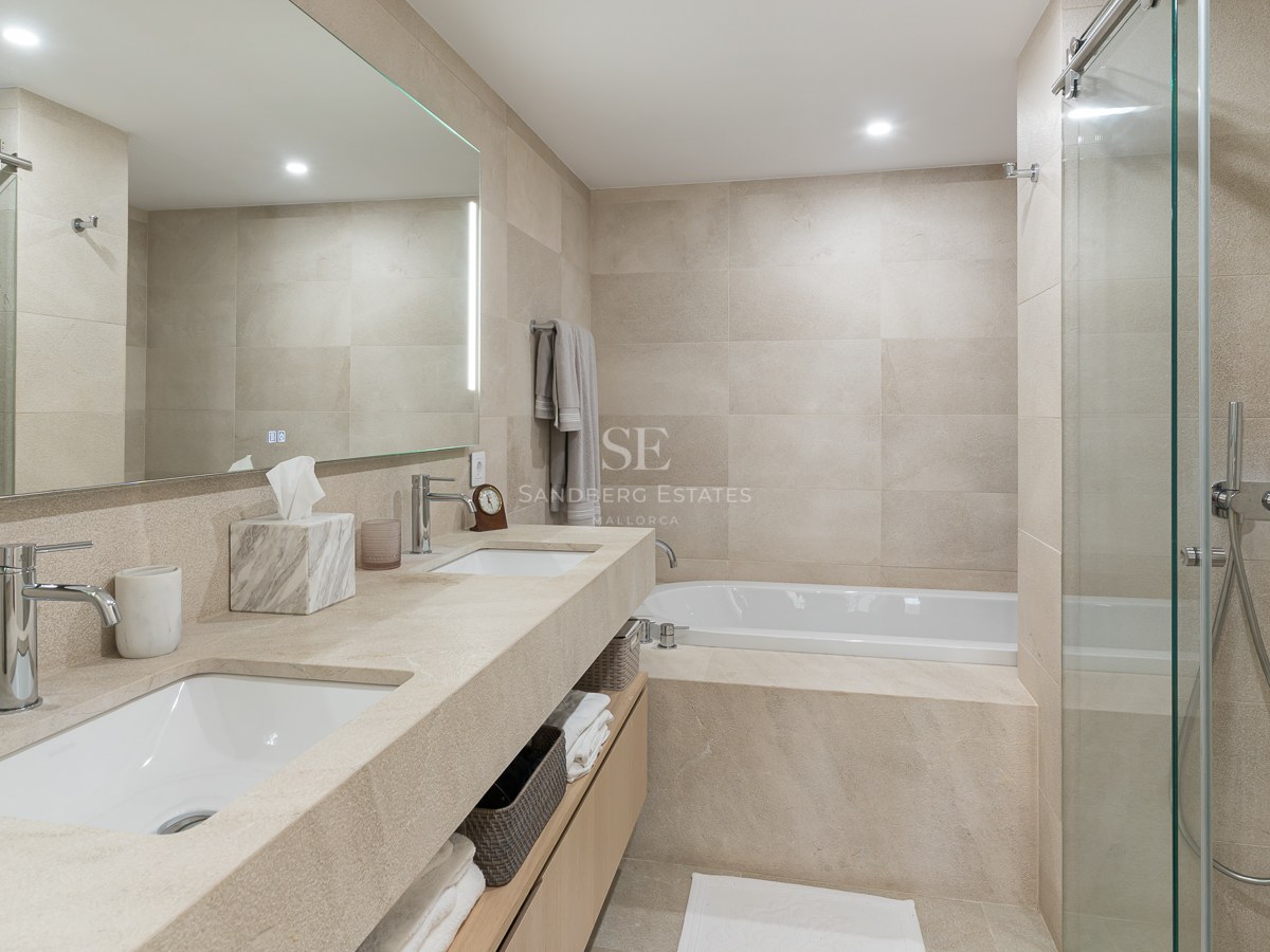 Salle de bains moderne avec double vasque en pierre, baignoire et douche à l'italienne vitrée.