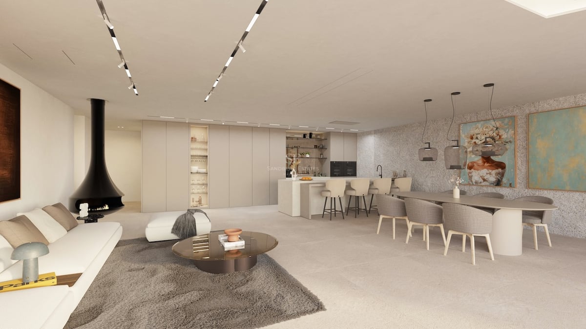 Espace de vie ouvert spacieux avec canapé blanc, cheminée noire design, salle à manger et cuisine aux tons neutres.