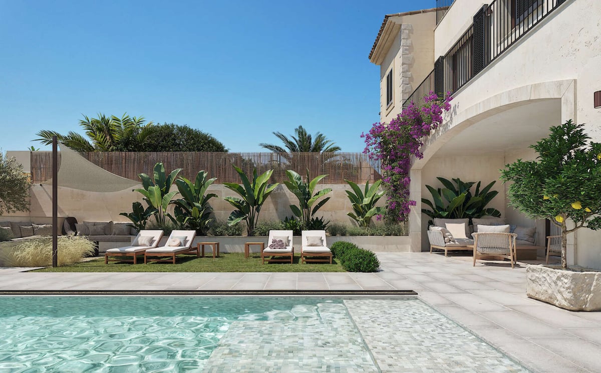 Espace piscine de luxe avec mosaïque turquoise, chaises longues sur pelouse et salon extérieur ombragé sous une arche.