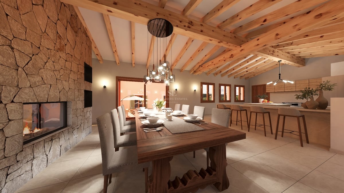 Grande salle à manger avec table en bois massif, cheminée en pierre et plafond aux poutres apparentes.