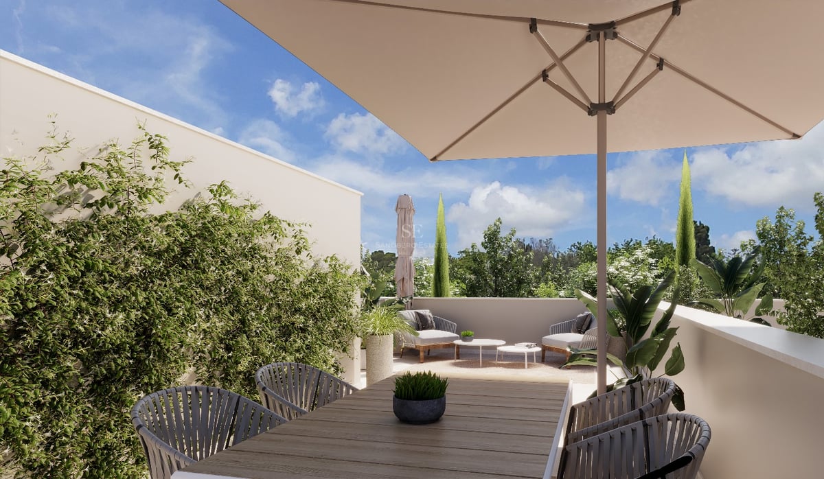 Terrasse ensoleillée avec table à manger en bois, grand parasol, fauteuils de salon et plantes luxuriantes.