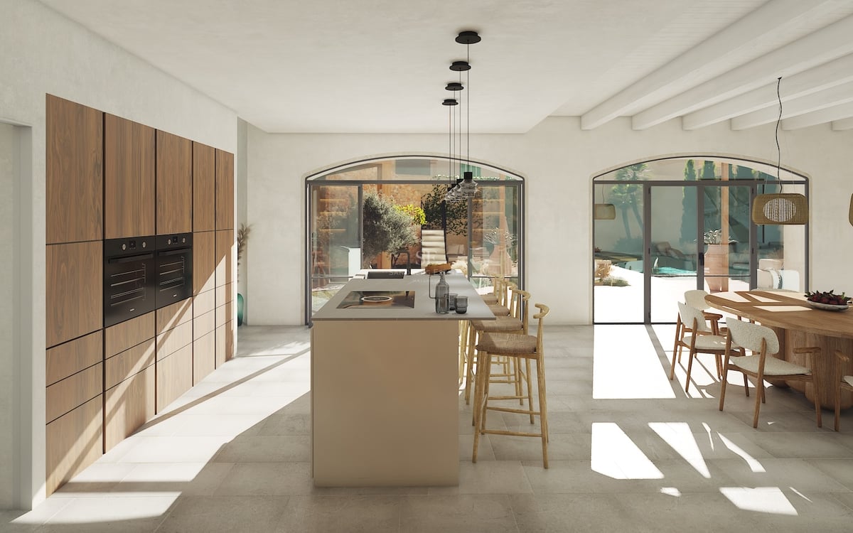 Cocina moderna de planta abierta con gran isla central, armarios de nogal y puertas de cristal en arco hacia el patio.