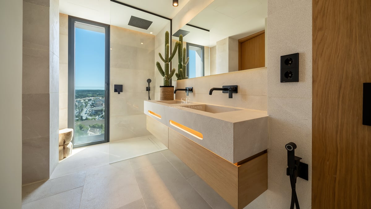 Salle de bains moderne avec double vasque en pierre, robinetterie noir mat, douche à l'italienne et grande fenêtre.