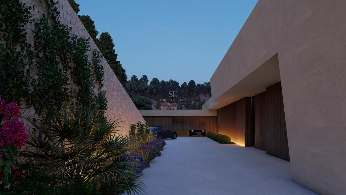 Vue nocturne de l'entrée d'une villa de luxe avec mur en pierre naturelle et éclairage encastré.