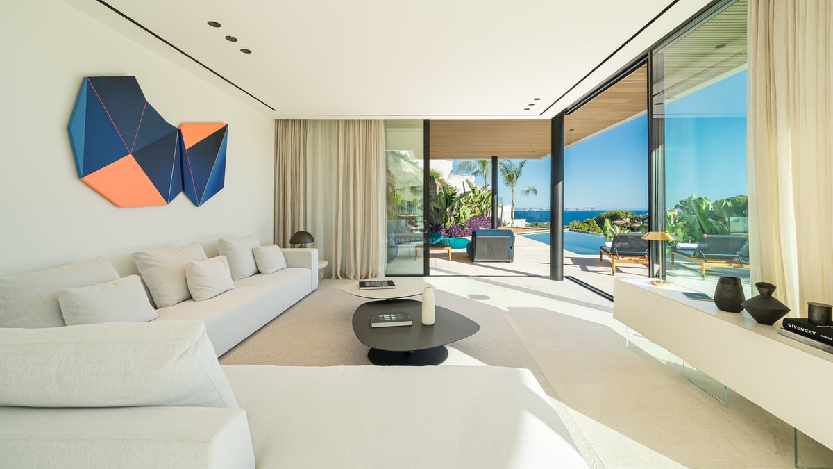 Vaste terrasse avec piscine à débordement et vue panoramique. Mobilier moderne et minimaliste. Idéal pour la détente et les loisirs.