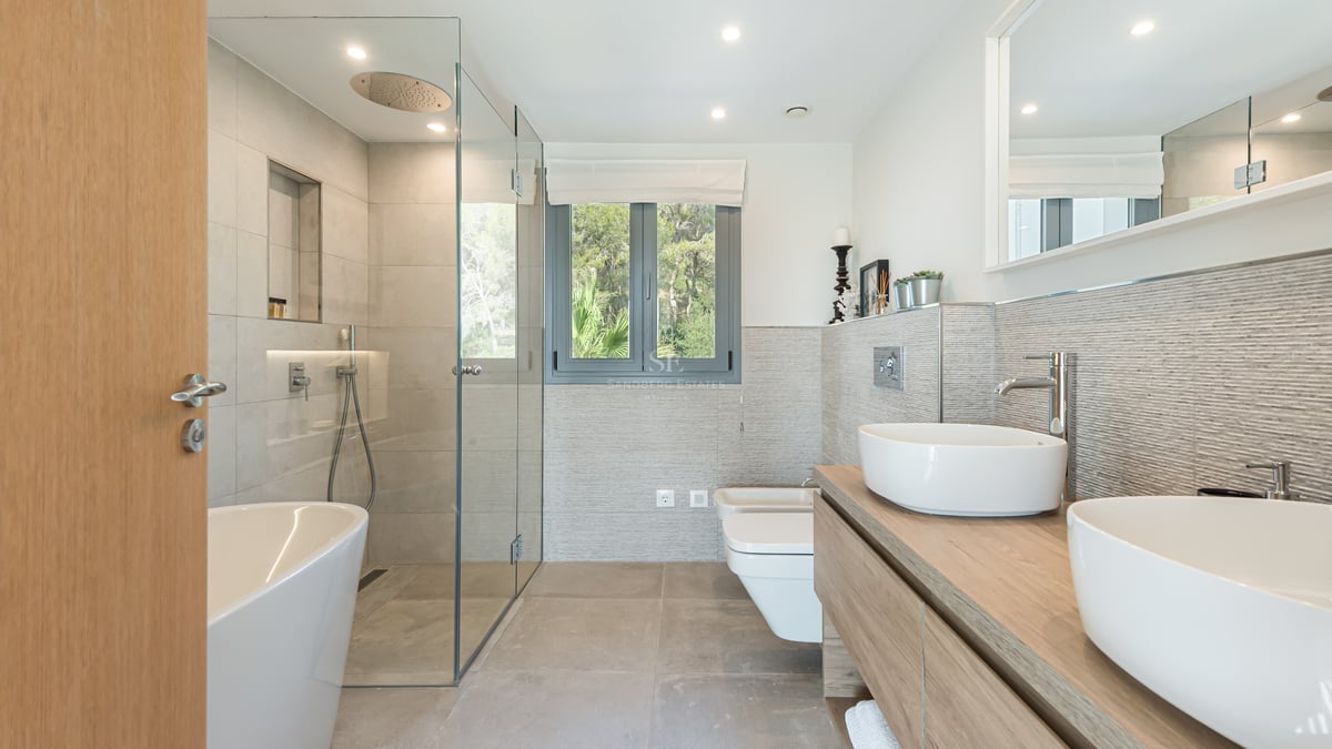 Salle de bains moderne avec douche à l'italienne, baignoire îlot et double vasque sur meuble en bois.