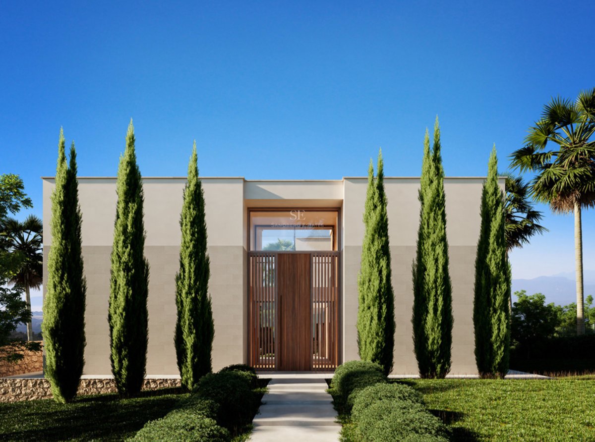 Entrée symétrique d'une villa moderne avec de grands cyprès, une porte en bois et un ciel bleu clair.
