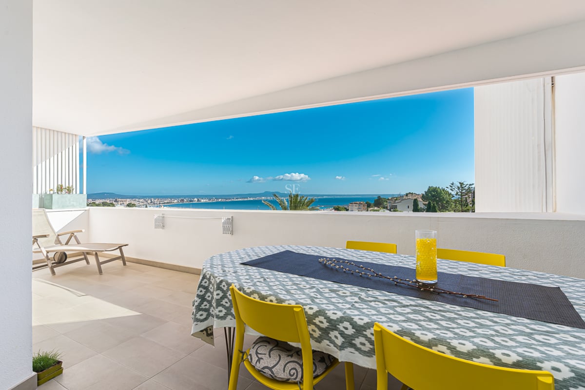 Grande terrasse avec piscine à débordement et vue sur la mer. Mobilier moderne et minimaliste. Éclairage d'ambiance.
