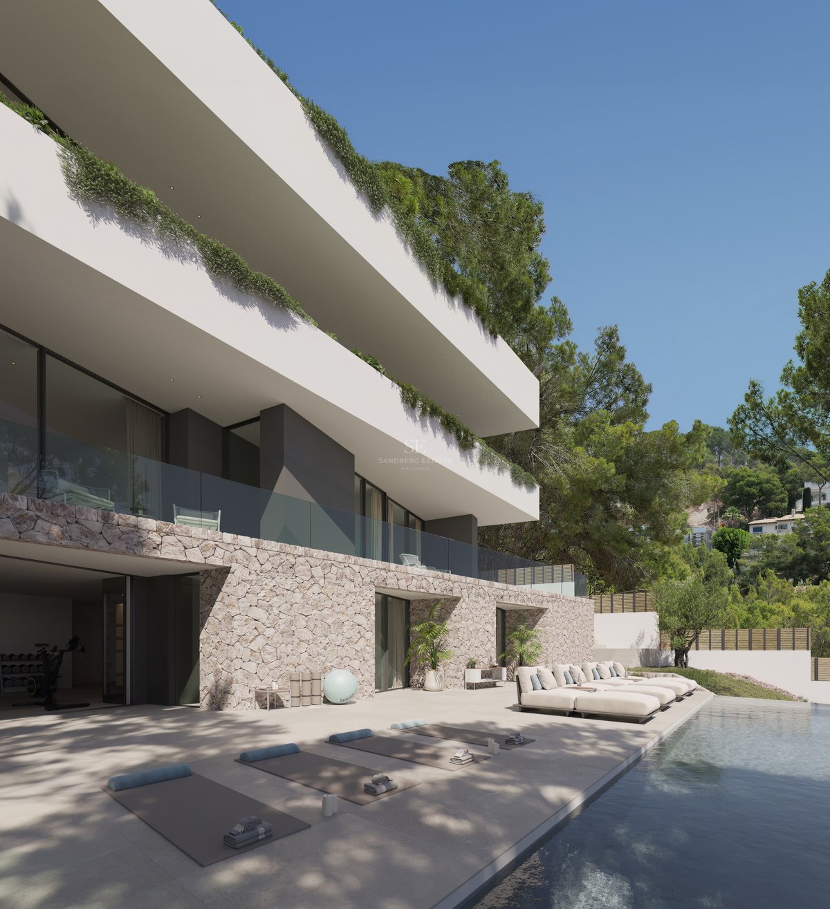 Terrasse de piscine avec bains de soleil et tapis de yoga devant une villa moderne en pierre et blanc.