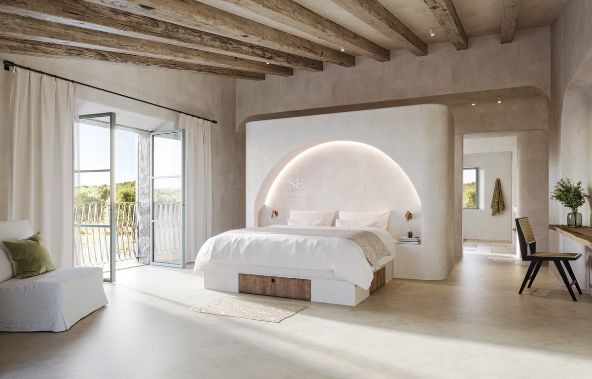 Chambre spacieuse avec poutres en bois, arche rétroéclairée et portes-fenêtres ouvrant sur un paysage naturel.