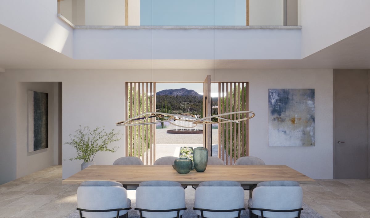 Salle à manger moderne avec table en chêne, luminaire design et vue panoramique sur les montagnes via une porte pivotante.
