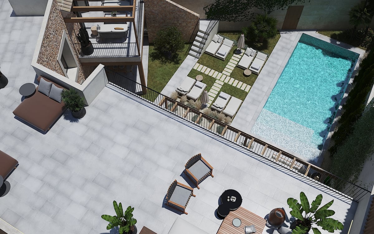 Vista aérea de una villa moderna con piscina turquesa, muros de piedra natural y amplias zonas de descanso exteriores.