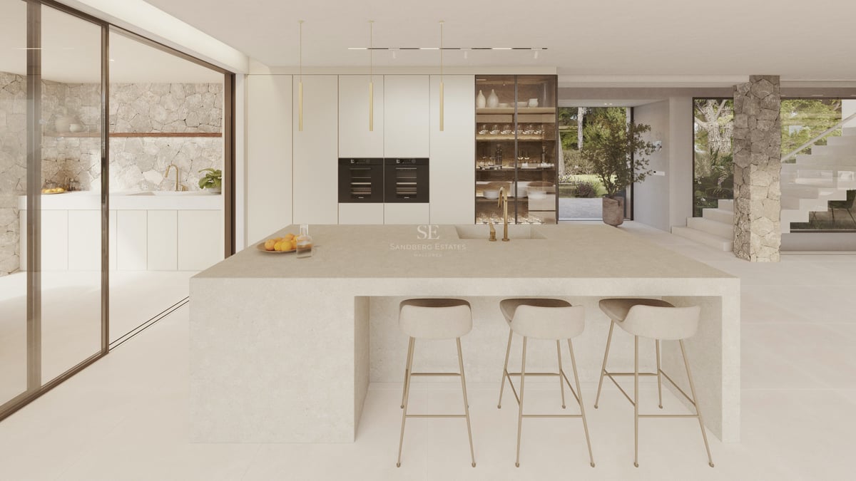 Une cuisine minimaliste et moderne dotée d'un grand îlot central en pierre, de tabourets beiges et de murs en pierre.