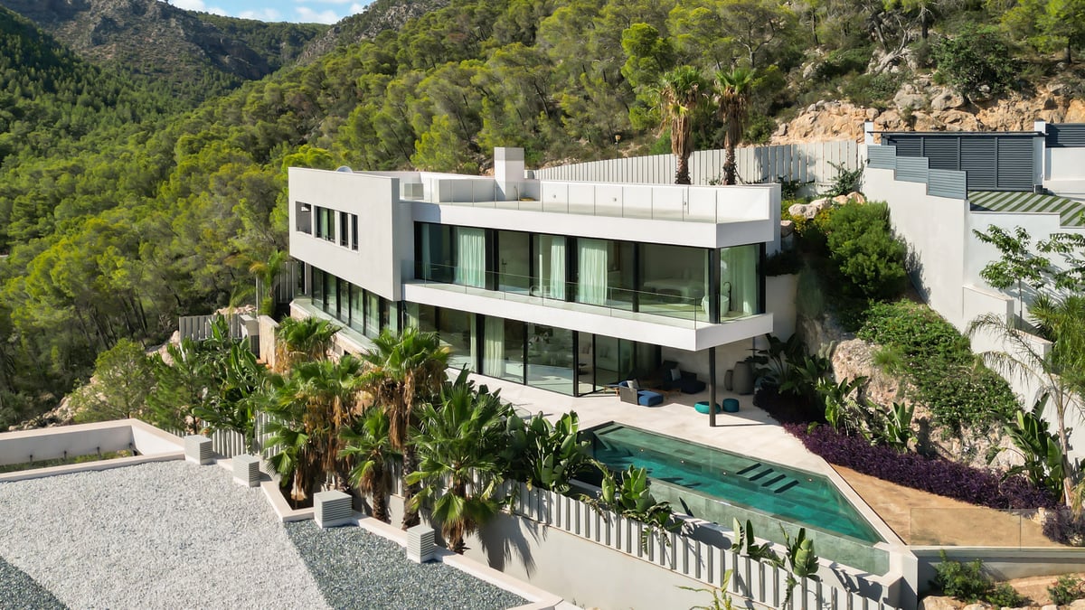 Vue extérieure d'une villa luxueuse avec piscine à débordement, jardin luxuriant et architecture moderne. Idéal pour investissement.