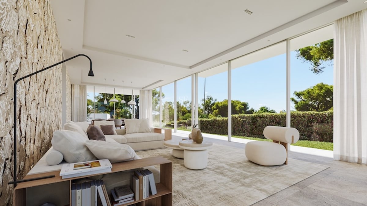 Salon minimaliste spacieux avec baies vitrées toute hauteur, canapé modulable crème et vue sur le jardin.