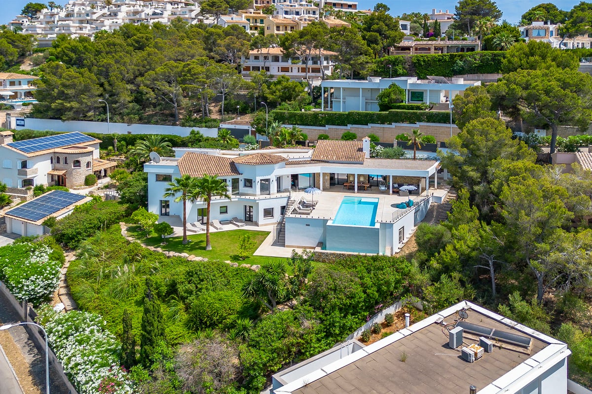 Vue extérieure d'une maison moderne avec piscine. Architecture minimaliste, grandes baies vitrées, jardins luxuriants et aménagement paysager élégant.