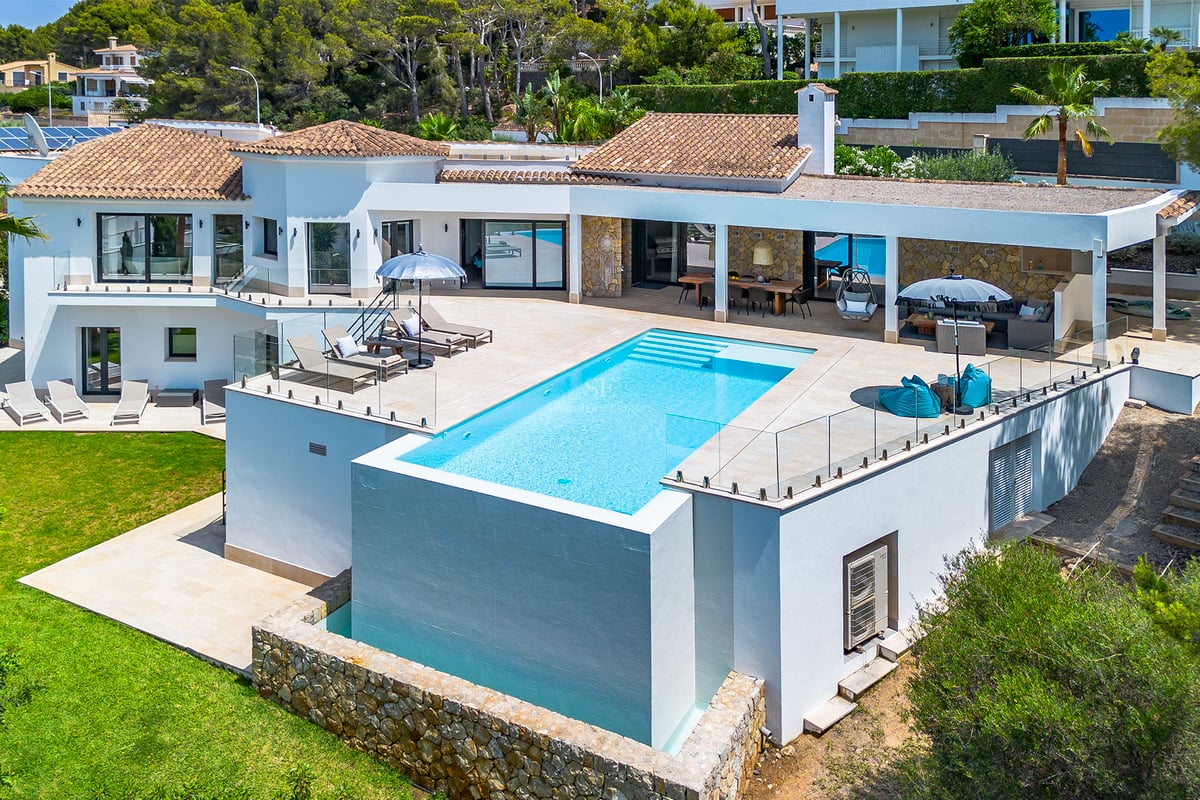 Salon spacieux avec baies vitrées, mobilier moderne et accès à un balcon avec vue imprenable. Élégance et luminosité.