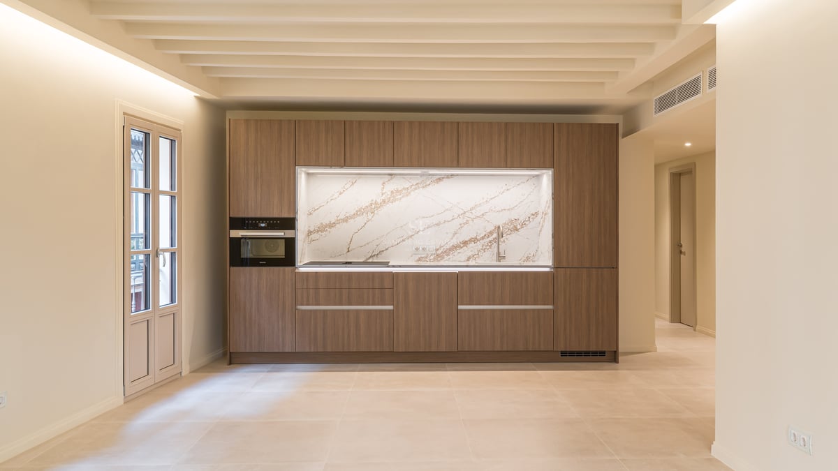 A contemporary kitchen featuring walnut cabinetry, a veined marble backsplash, and integrated Miele appliances.
