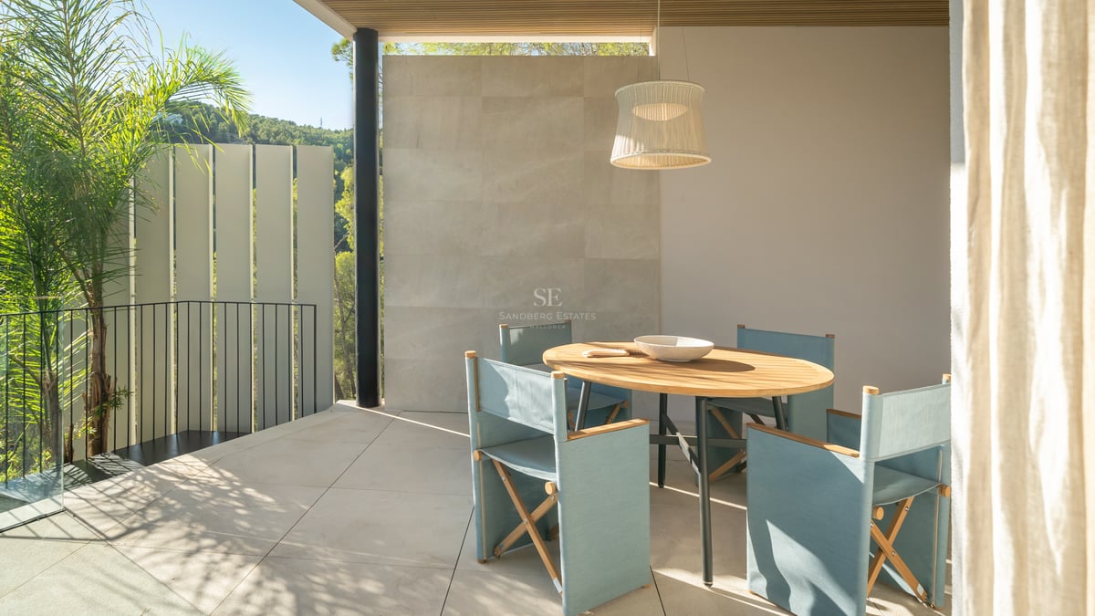 Salon lumineux avec grandes baies vitrées, piscine à débordement, parquet et mobilier moderne élégant.
