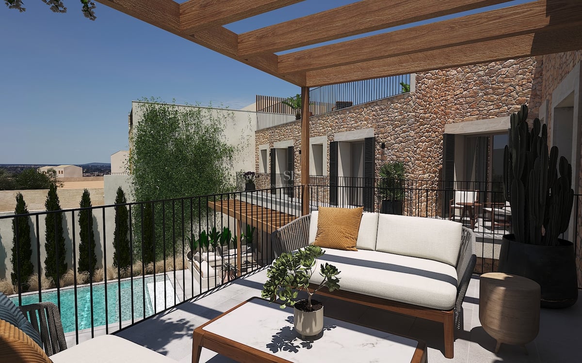 Terraza moderna con pérgola de madera, sofá de diseño y pared de piedra natural con vistas a una piscina inferior.