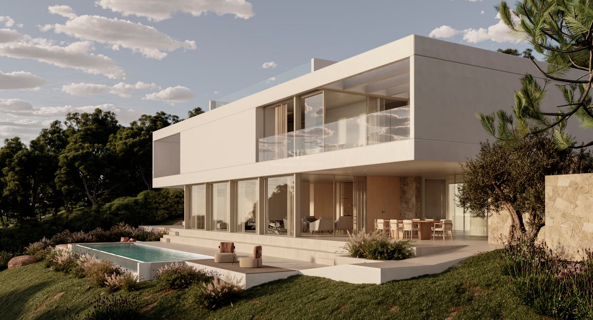 Villa blanche moderne sur deux niveaux avec baies vitrées et piscine à débordement à la tombée du jour.