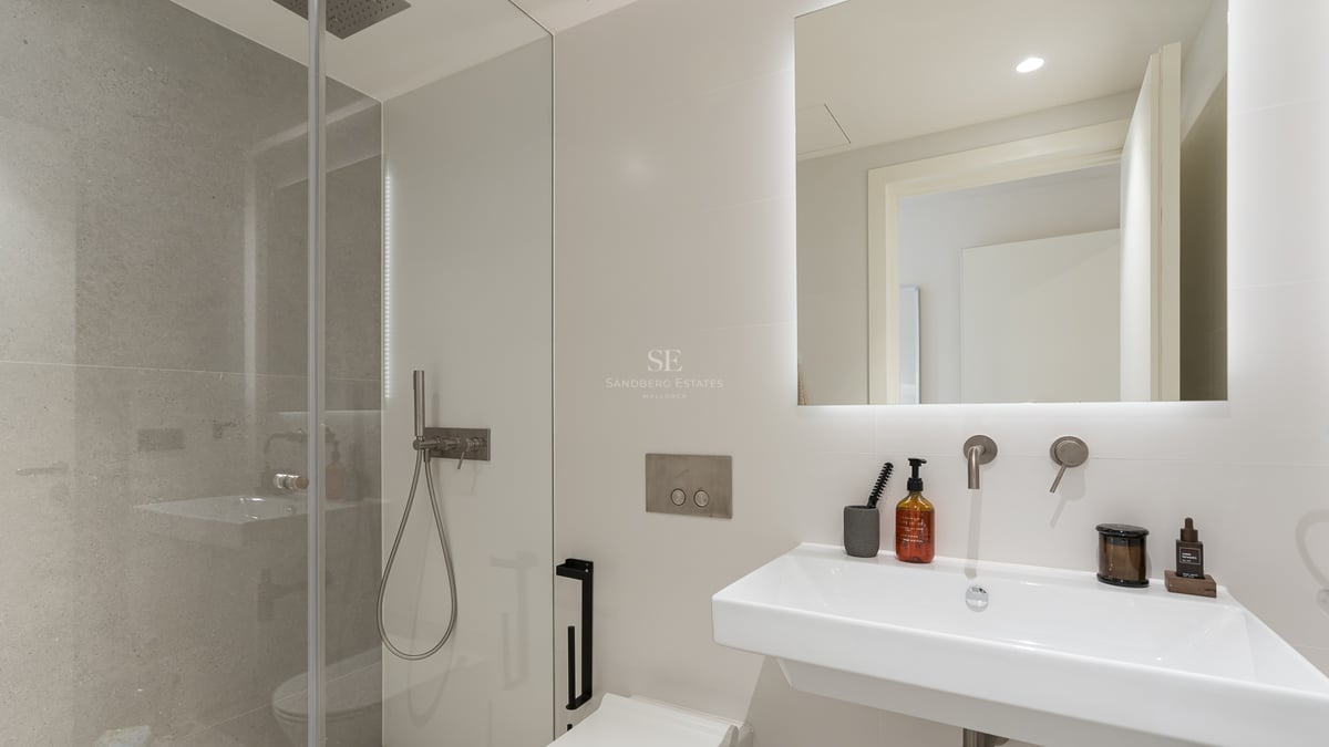 Salle de bains contemporaine avec douche à l'italienne, vasque blanche et grand miroir rétroéclairé.