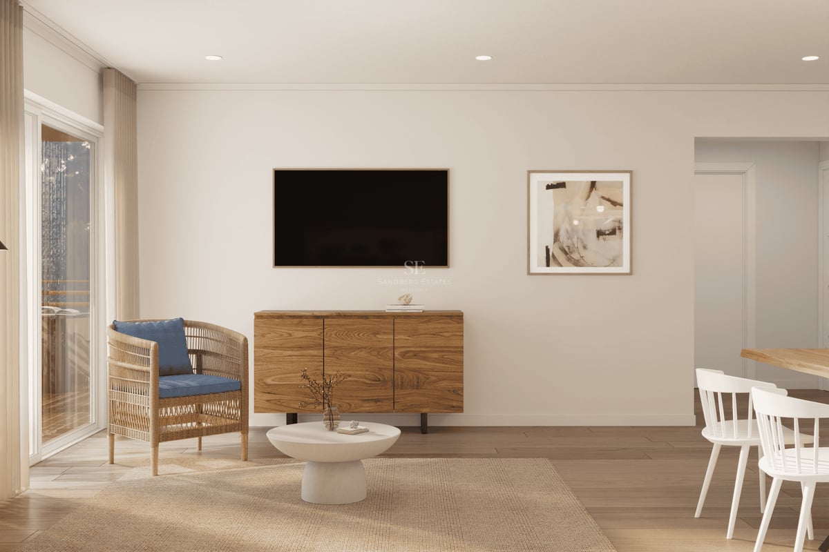 Minimalistiskt vardagsrum med korgstol, väggmonterad TV och stilren träskänk.