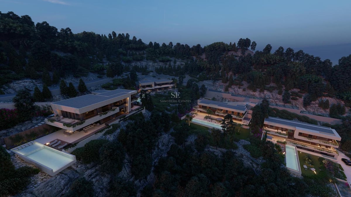 Vue aérienne au crépuscule de villas de luxe contemporaines avec piscines à débordement sur une colline arborée.